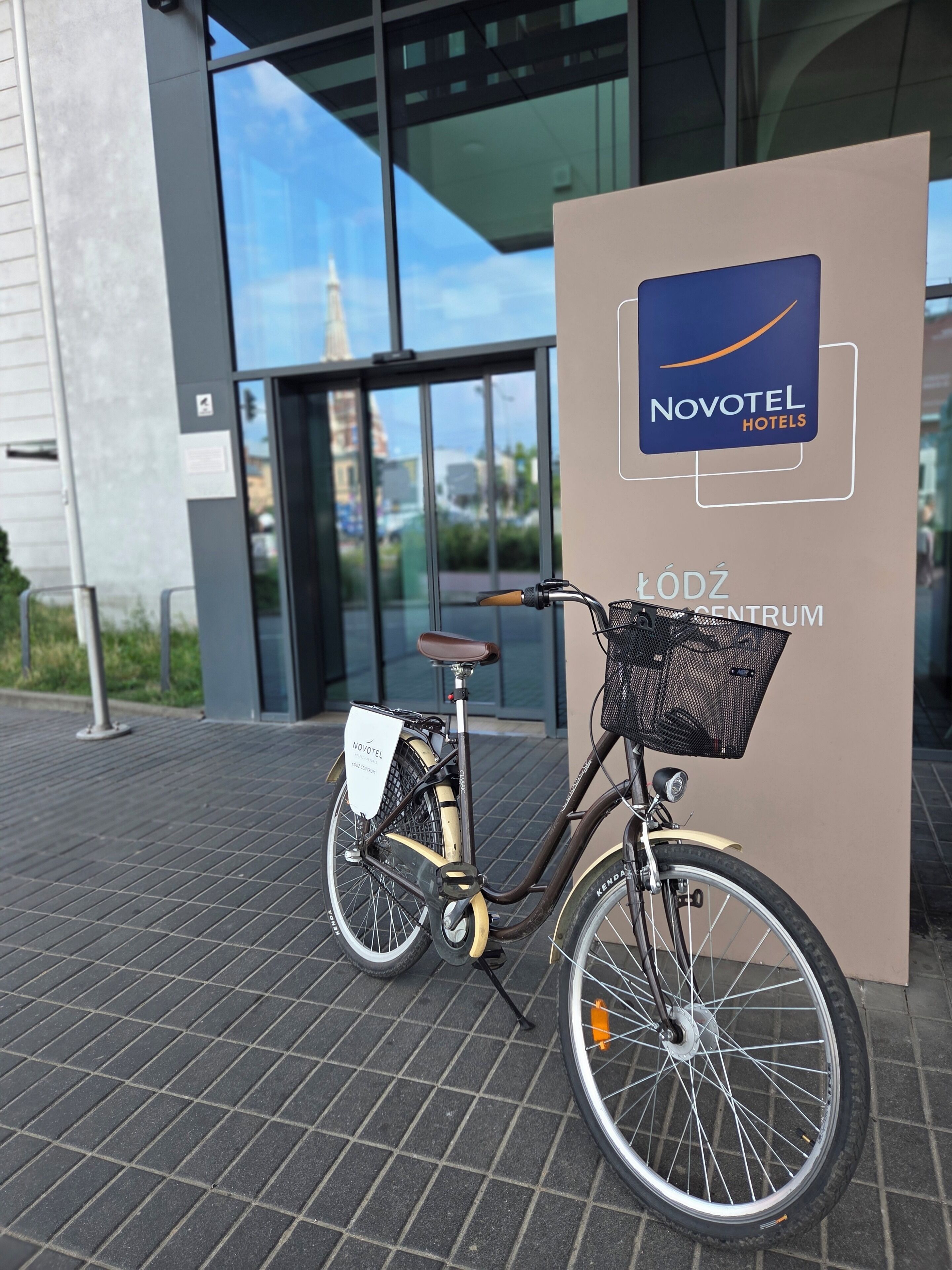 Ein Fahrrad vor einem Novotel Hotel, auf dem der Hotelname steht.