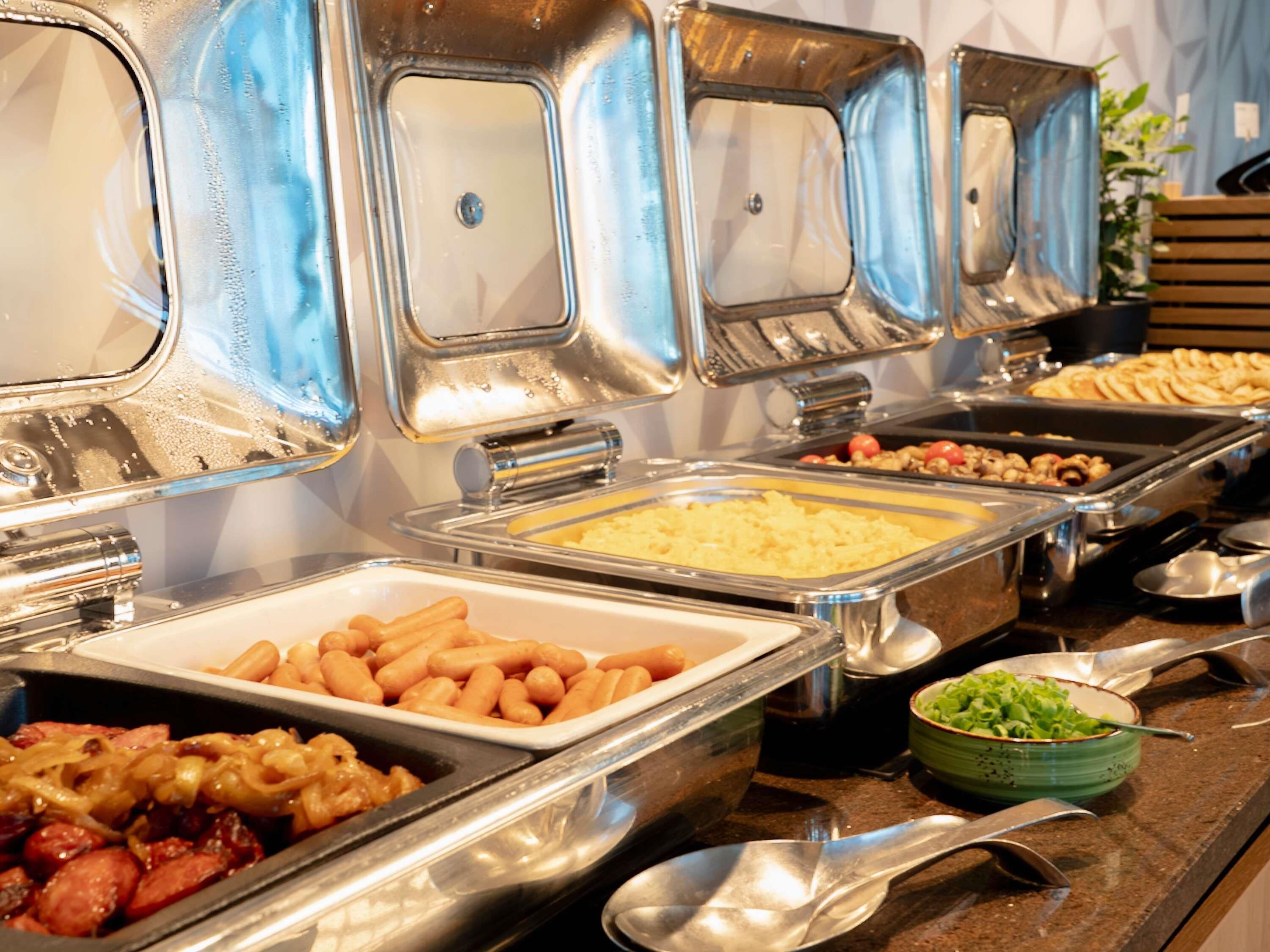 Ein Buffet mit verschiedenen Speisen in Metallbehältern.