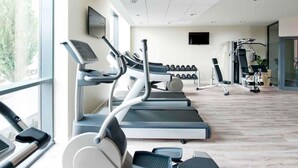 A gym with treadmills, dumbbells, and exercise equipment. - Novotel Lodz Centrum (Lodz)