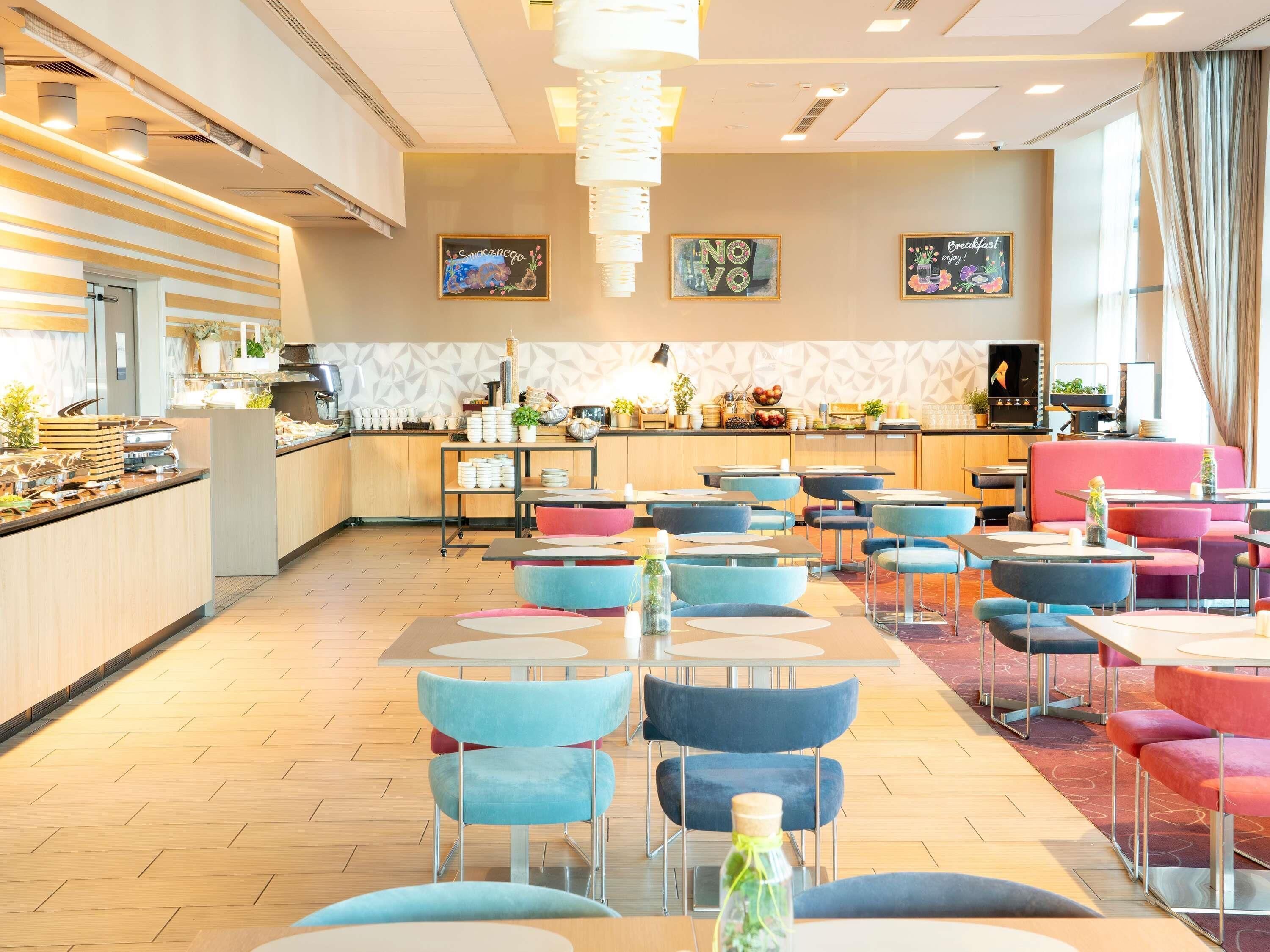 Ein moderner Essbereich mit Buffet, verschiedenen Sitzgelegenheiten und einer Küche im Hintergrund.