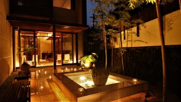A modern building with a glass entrance, a water feature, and a bench. - Hotel Allamanda (Nara)