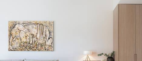 A modern living room with a white sofa, a coffee table, a wooden cabinet, and a painting on the wall.