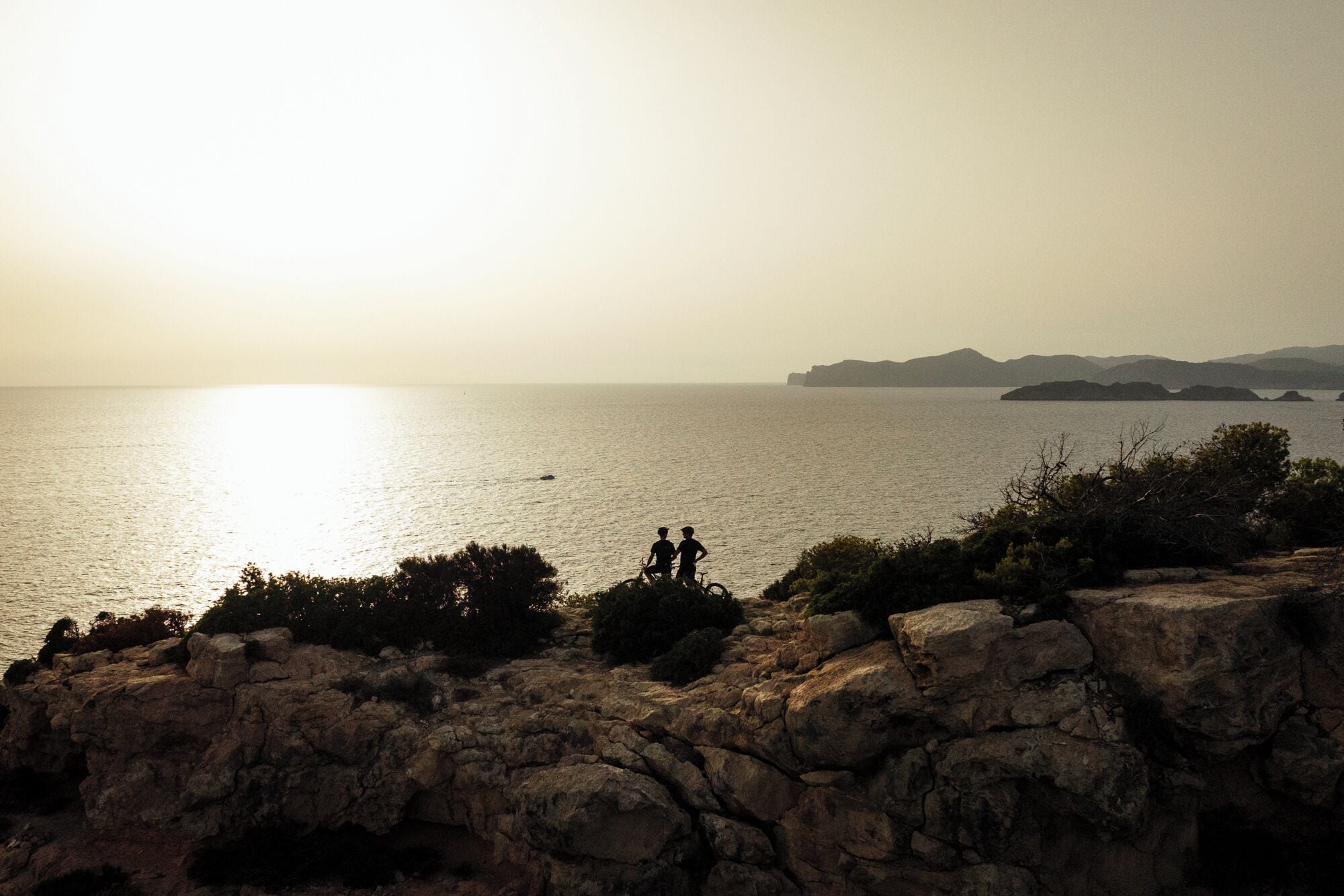 A coastal view with rocky terrain and a distant island.