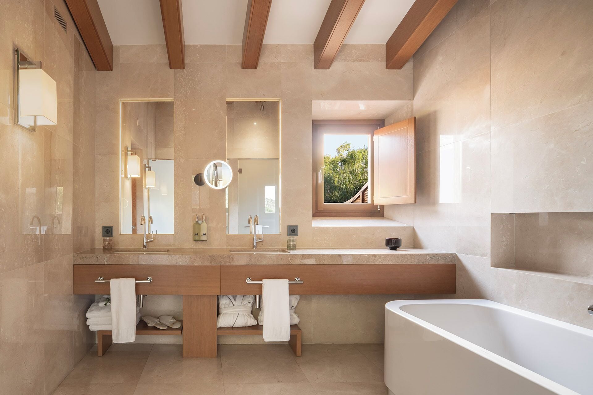 A modern bathroom with a large bathtub, a double vanity with two sinks, and a large mirror.