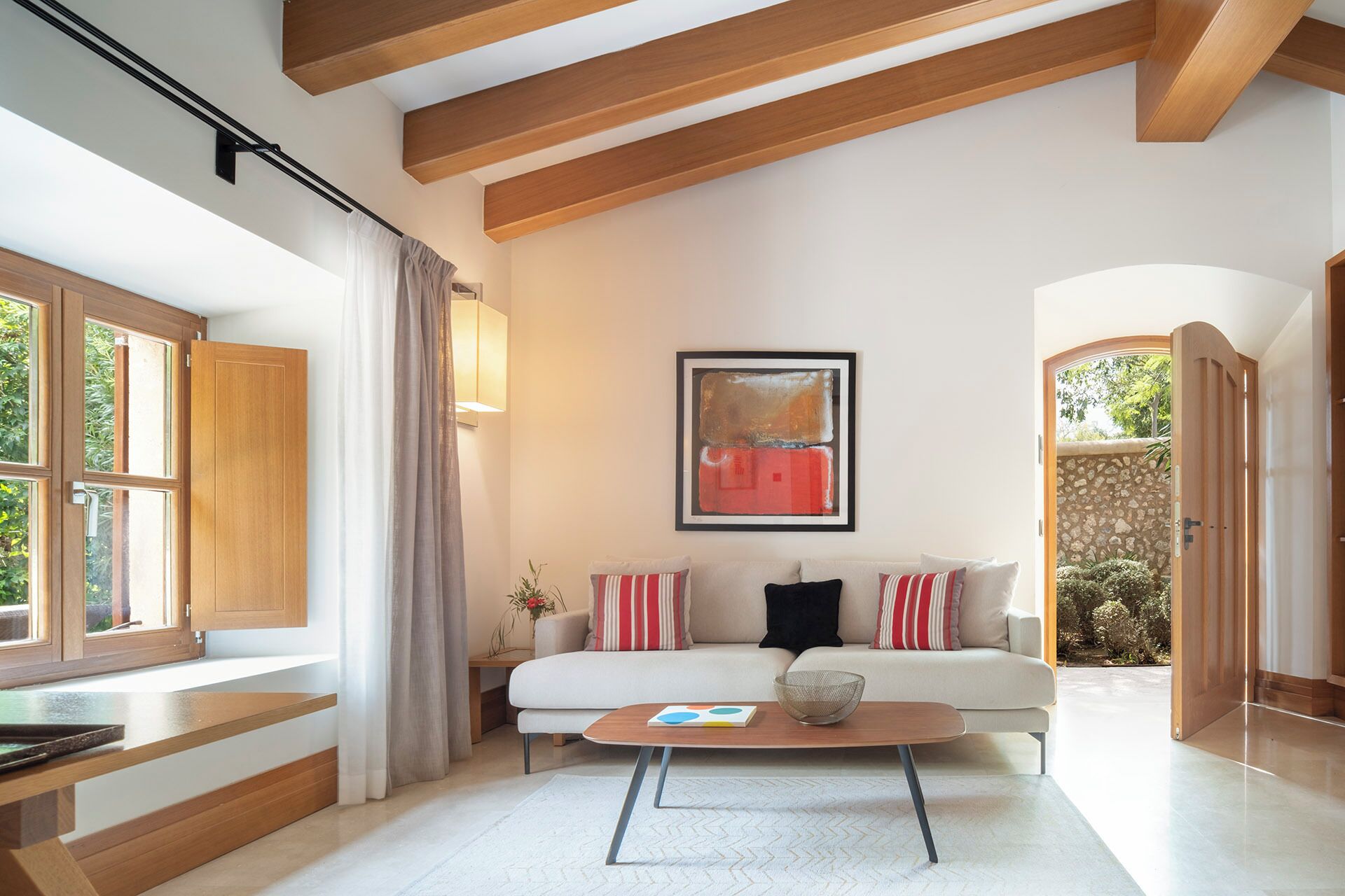 Un salon moderne avec un canapé, une table basse et des œuvres d’art accrochées au mur.