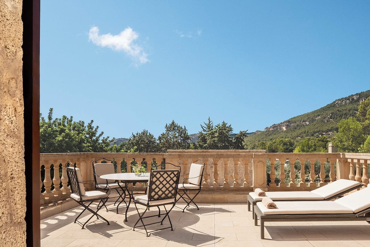 A terrace with a table and chairs, a small round table, and two sun loungers.
