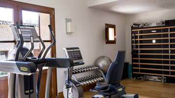 A home gym with treadmills, an elliptical, dumbbells, and a stationary bike.