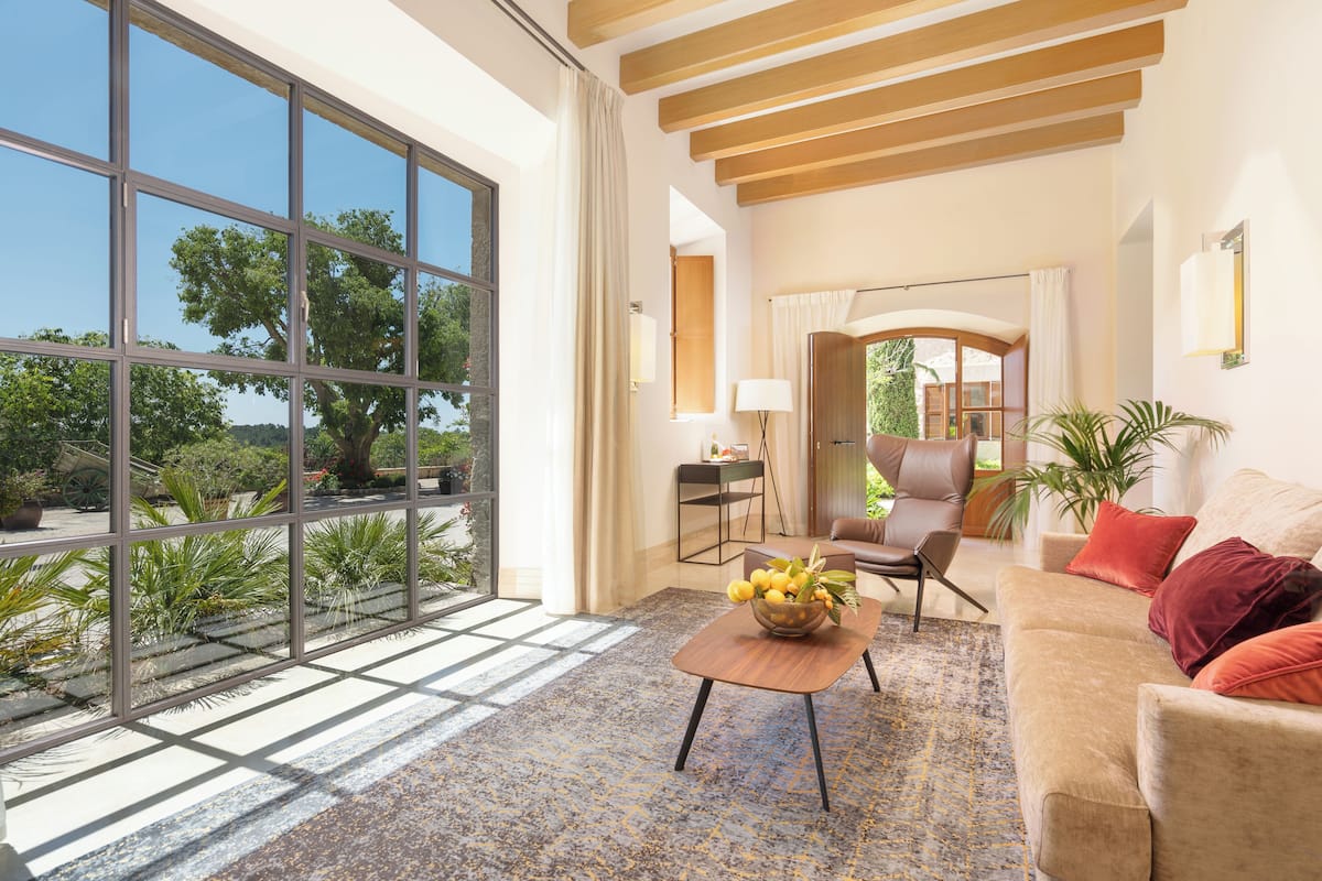 A spacious living room with large windows, a wooden ceiling, and a comfortable seating area.