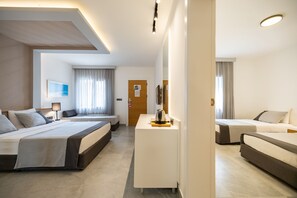 A hotel room with two beds, a desk, a coffee maker, and a view of the sea through the window. - Kadikale Resort Spa (Bodrum)