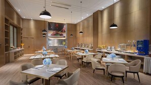A modern restaurant with multiple dining tables and chairs, wooden paneling on the walls, and pendant lighting. - Ramada by Wyndham Changsha Financial Center (Changsha)