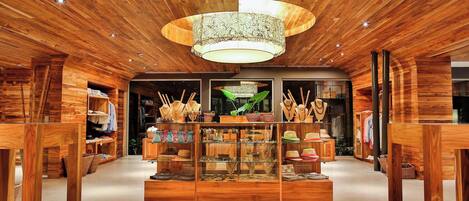 A wooden interior with a central display case, wooden shelves, and a ceiling with embedded lights.