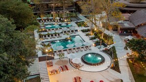 An aerial view of a resort with multiple swimming pools, lounge areas, and a circular hot tub. - El Mangroove Papagayo, Autograph Collection (Sardinal)