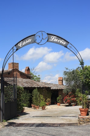 Een metalen poort met de tekst ‘Casa Lucia’ en een rond logo.