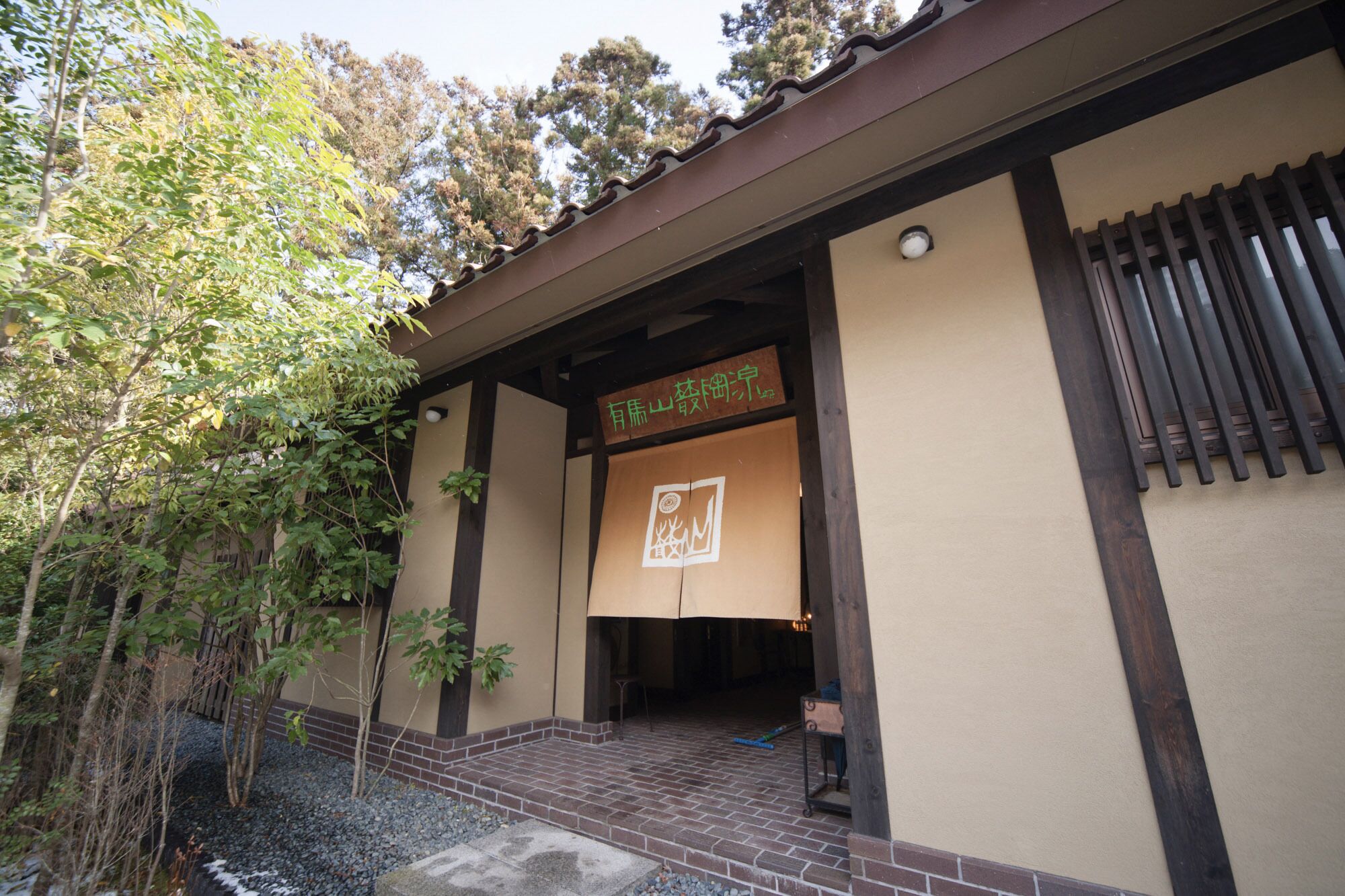 Un edificio japonés tradicional con entrada de tejas y un cartel.