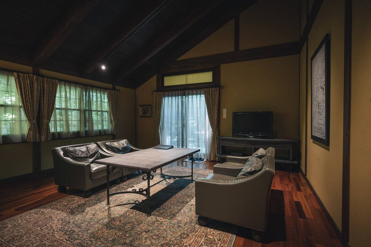 Un salón con sofá, mesa y televisor.