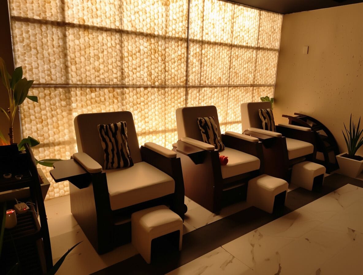 Un cuarto de spa con sillones de masaje, camilla de masaje y un amplio ventanal con pared texturizada.