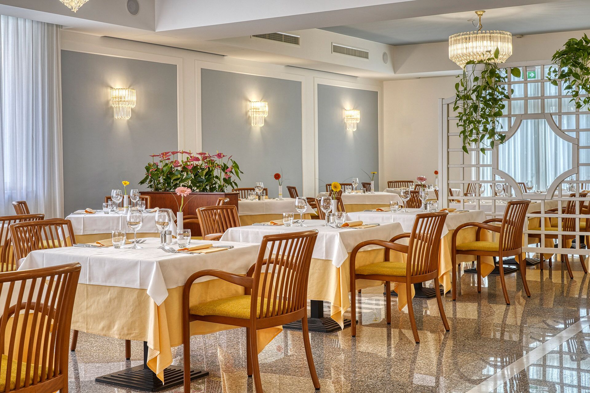 Un restaurante con varias mesas, sillas y candelabros.