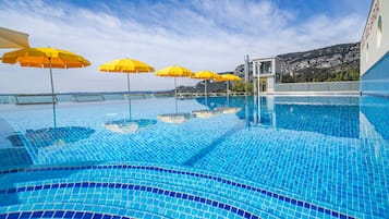 Piscine extérieure, parasols de plage, chaises longues