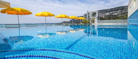 Piscine extérieure, parasols de plage, chaises longues