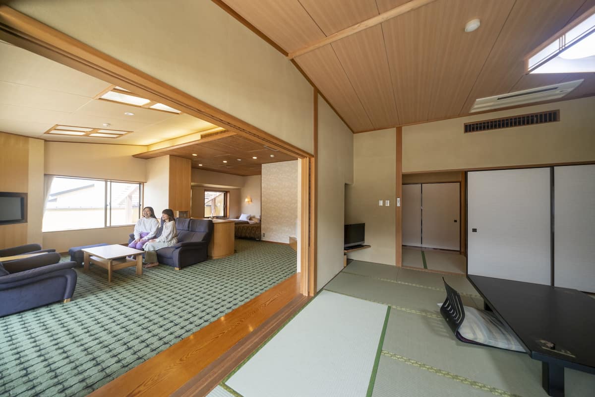 A traditional Japanese-style room with tatami flooring, a low table, and a television.