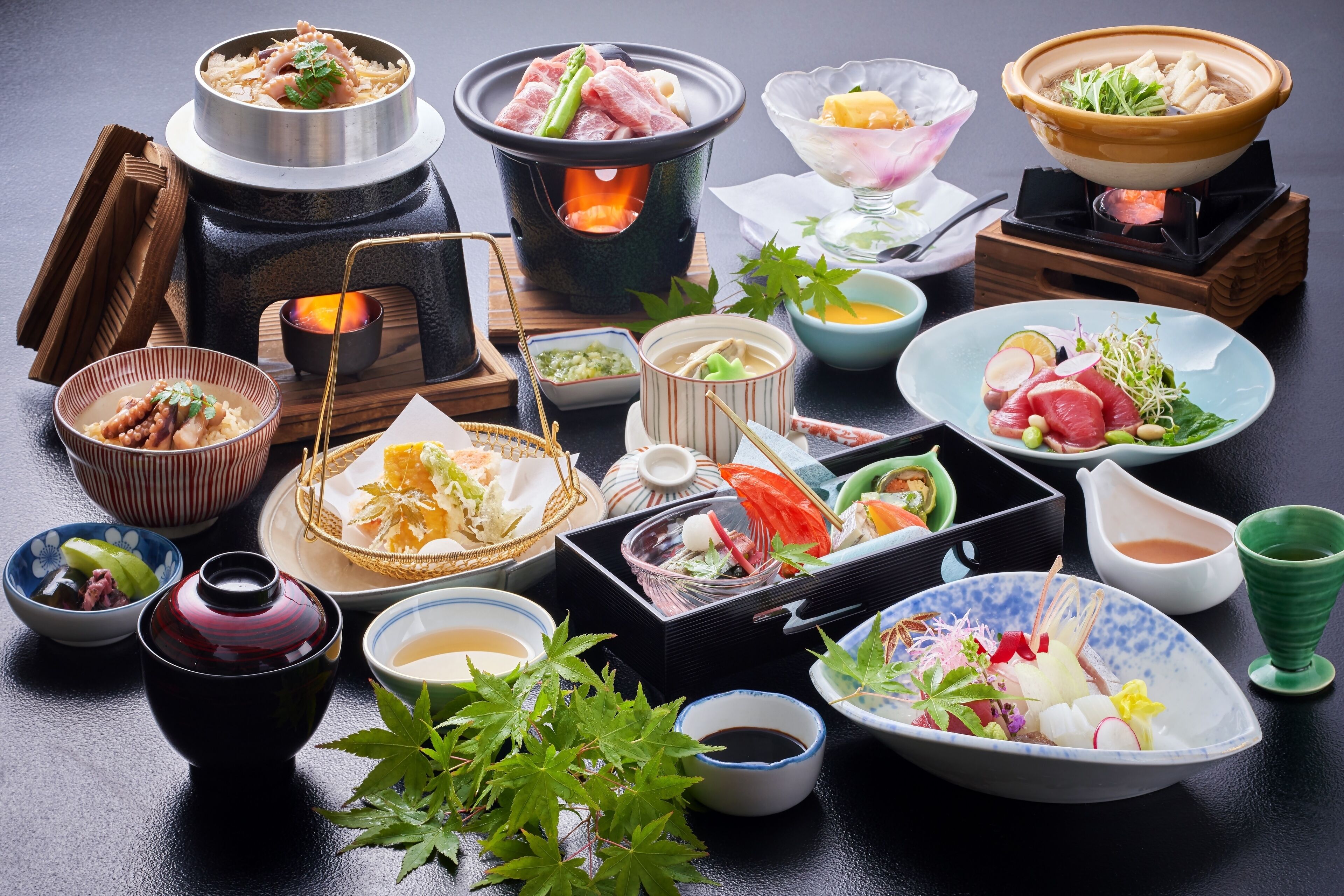 A variety of Japanese dishes and hot pots arranged on a table.