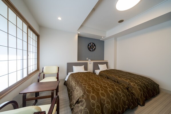 A hotel room with two beds, a desk, a chair, and a large window. - Hotel Miyarikyu (Hatsukaichi)