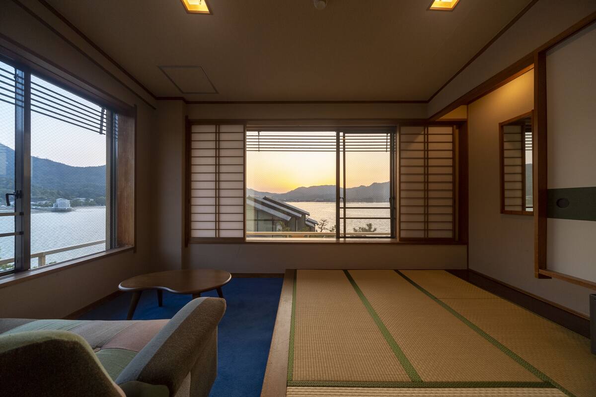 A traditional Japanese room with tatami flooring, a low table, and sliding doors.