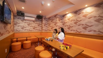 Relax in this stylish room with a geometric patterned wall, a long table, and a comfortable bench.