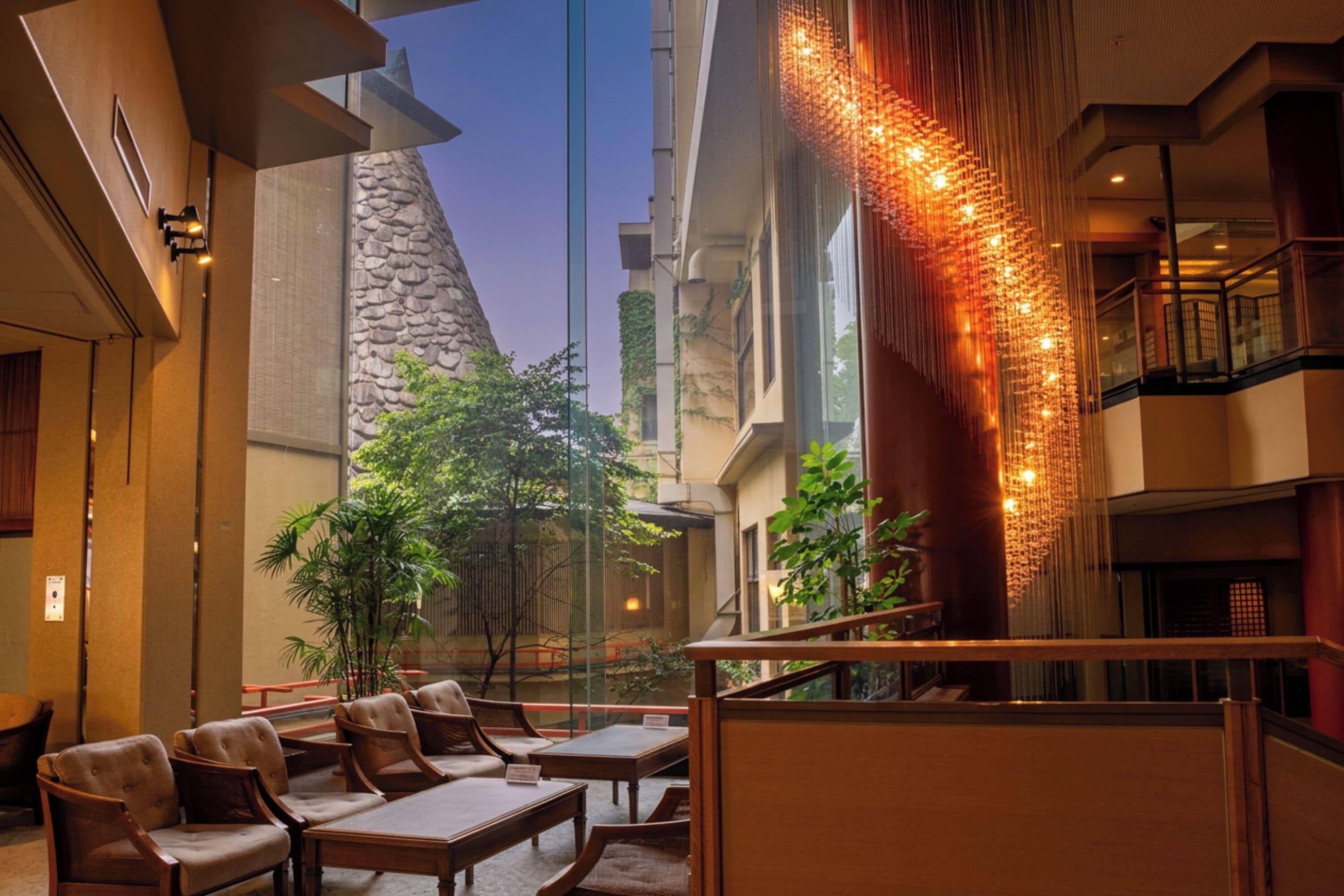 A hotel lobby with a seating area, a staircase, and a decorative wall.