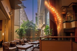 A hotel lobby with a seating area, a staircase, and a decorative wall. - Hotel Miyarikyu (Hatsukaichi)