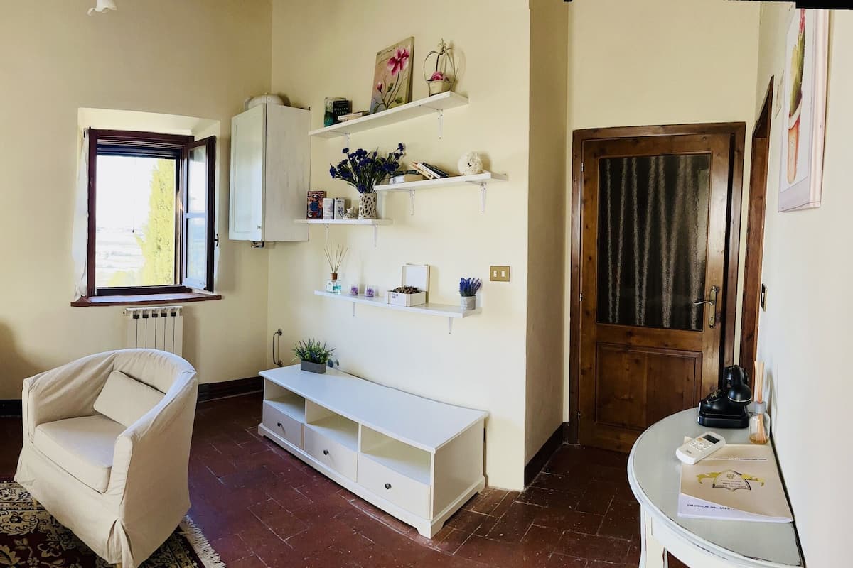 Un salon avec un canapé, une petite table, un radiateur et un téléviseur.