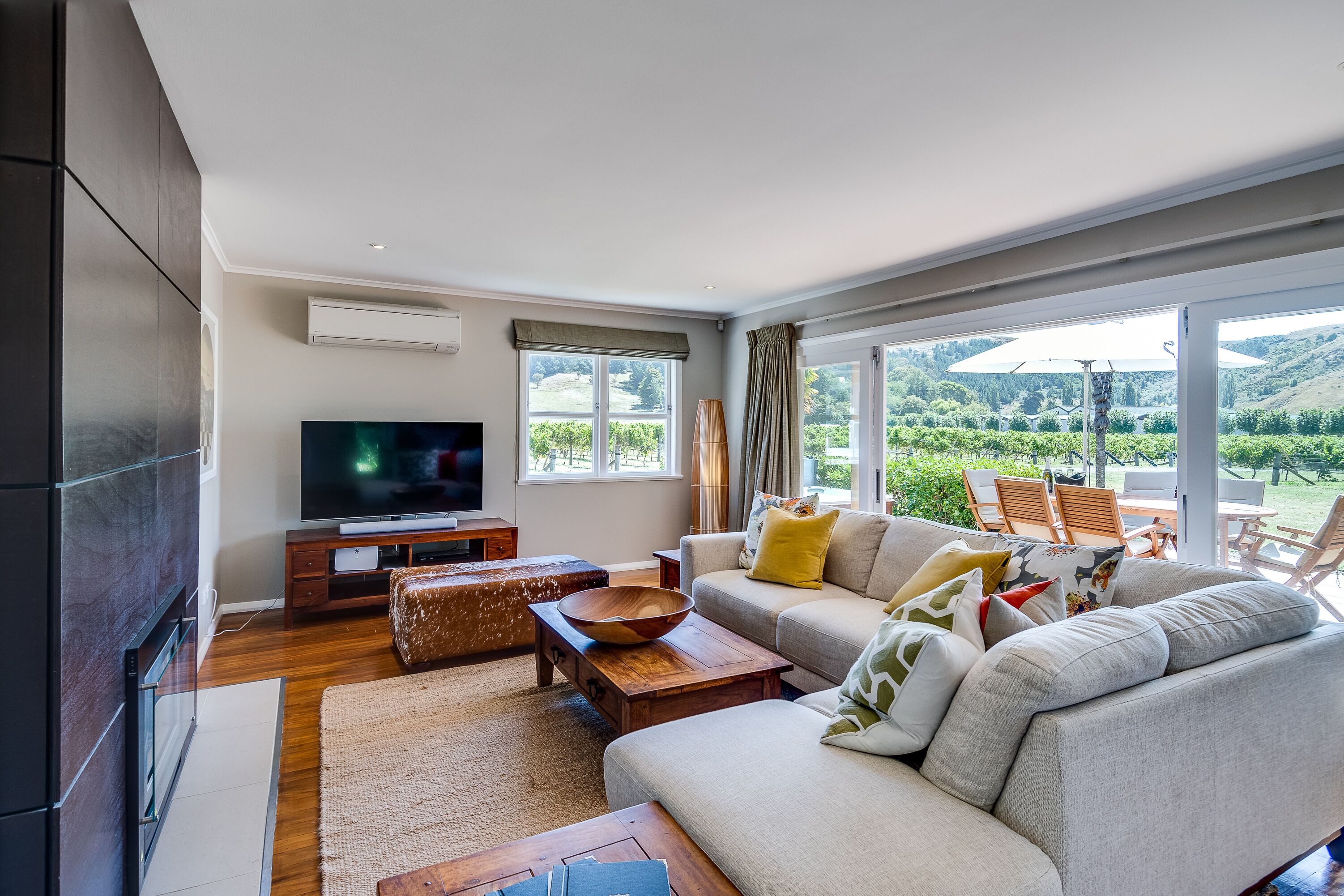 Una sala moderna con un televisor grande, asientos cómodos y vistas al exterior.