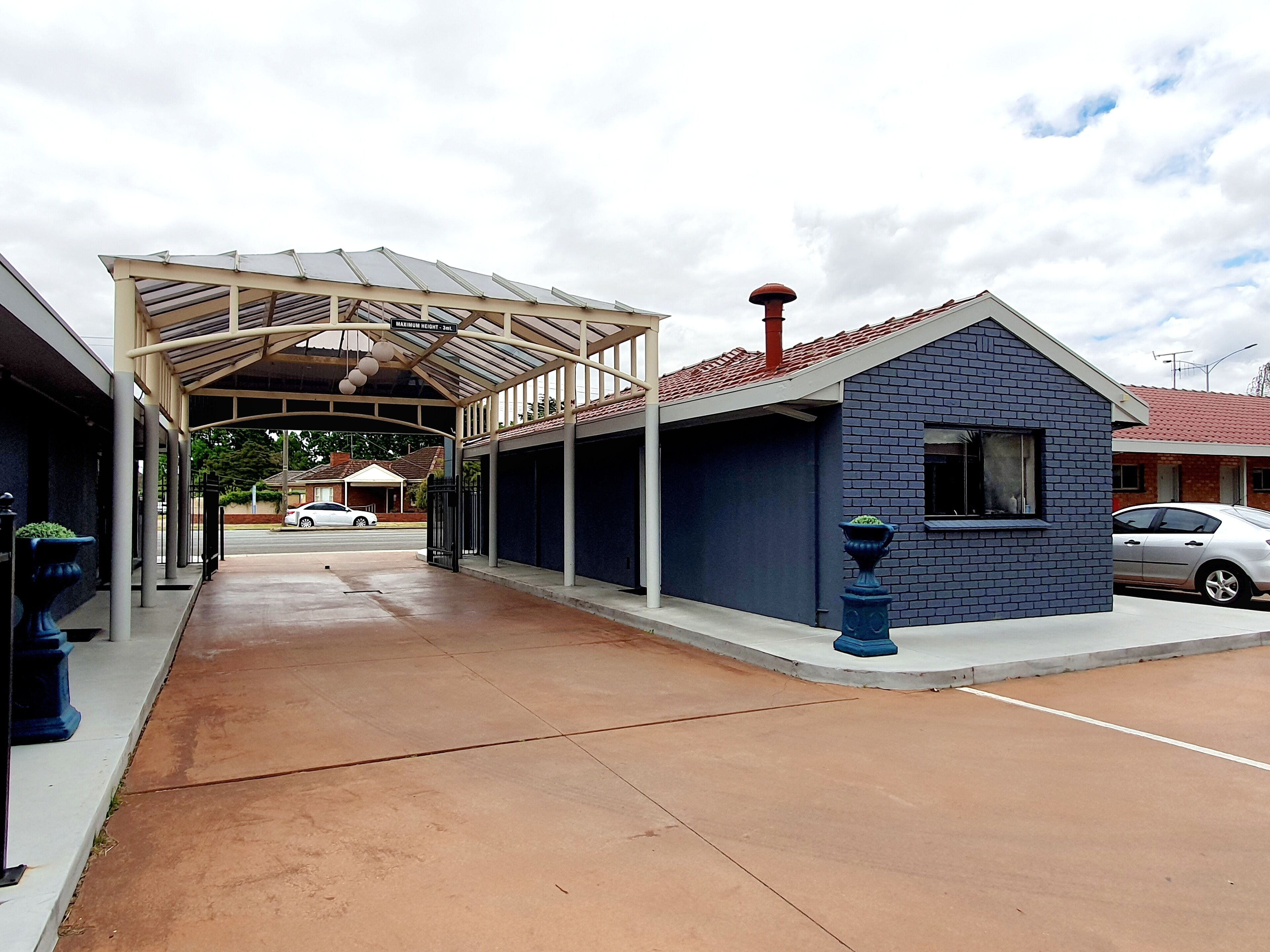 A covered parking area with a building adjacent to it.