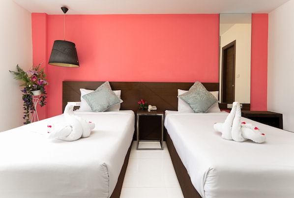 A hotel room with two beds, a nightstand, a lamp, and a mirror. - Grand Alpine Hotel (Bangkok)