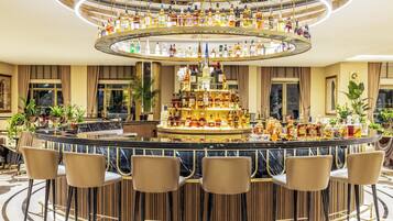 Un bar con un design circolare, numerose bottiglie di liquore e sgabelli da bar.