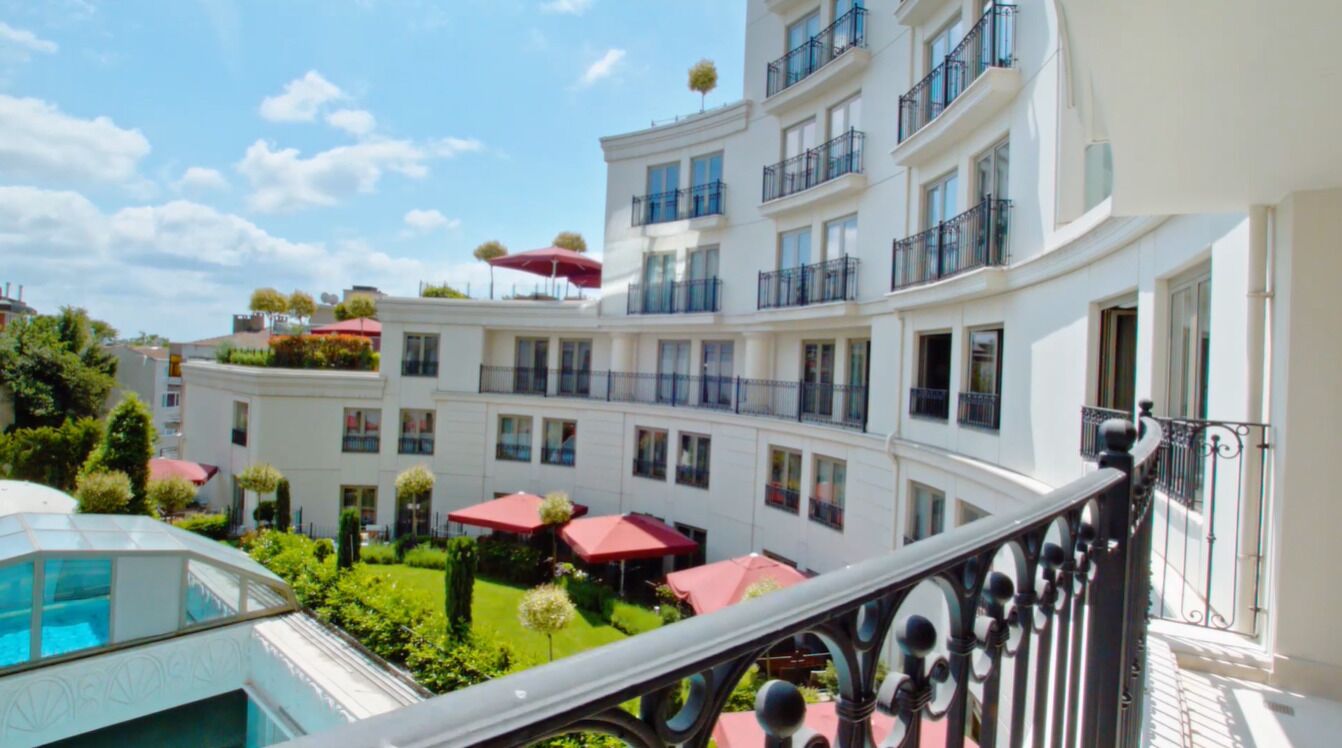 Ein mehrstöckiges Hotel mit Balkonen, Außenbereich und einem Pool.