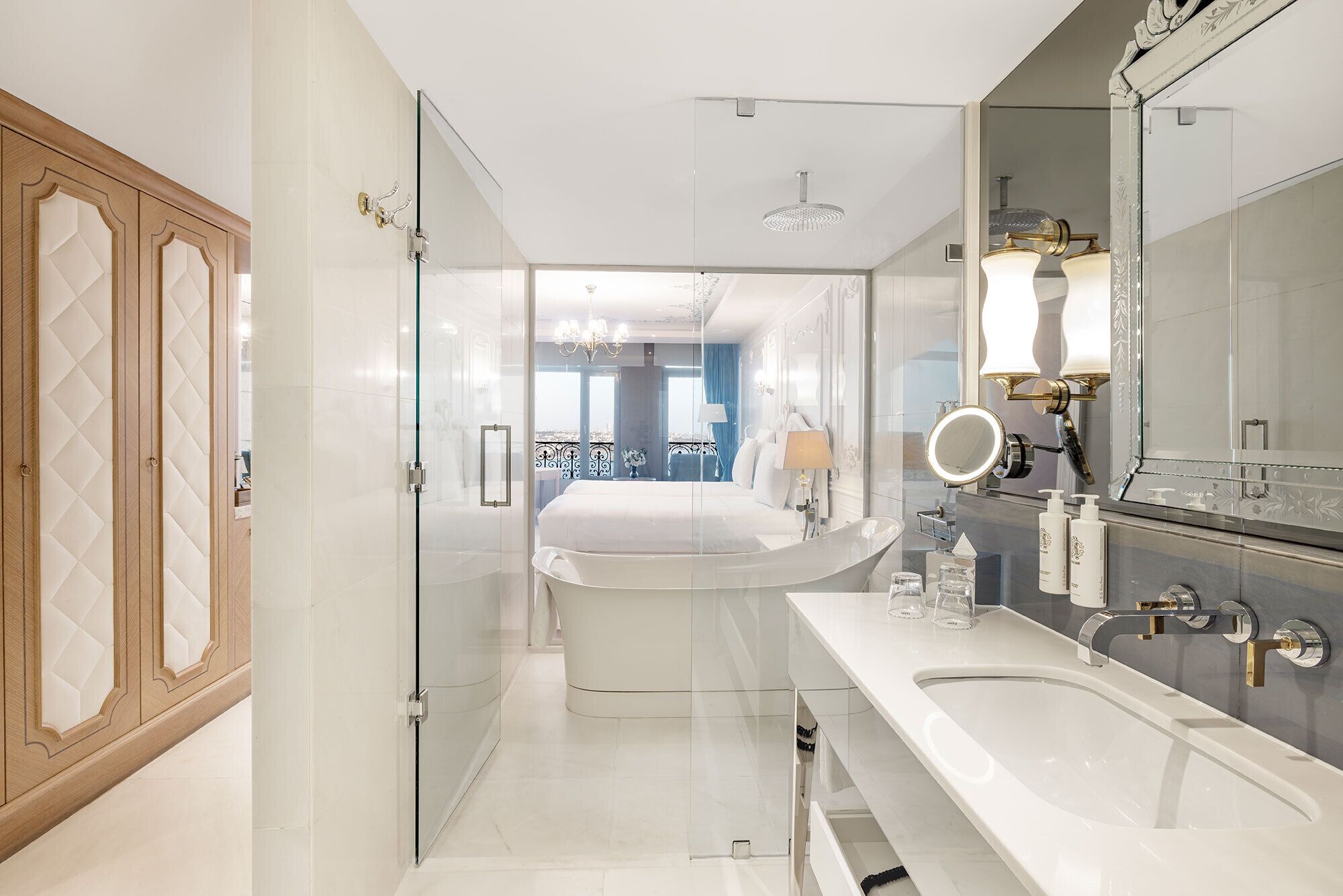 A modern bathroom with a large mirror, a bathtub, and a separate sink area.