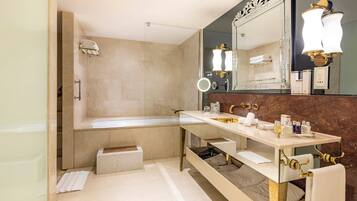 Un baño moderno con bañera, tocador con espejo y lavamanos.