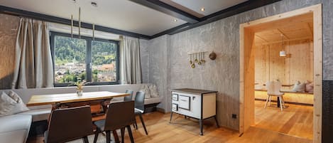 Un espace repas moderne avec une table et des chaises en bois, un banc intégré et une vue sur l’extérieur.
