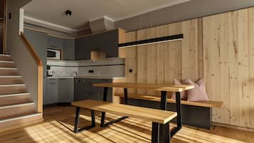 Een moderne keuken met houten vloeren, inbouwapparatuur en een eethoek met een bank en tafel.