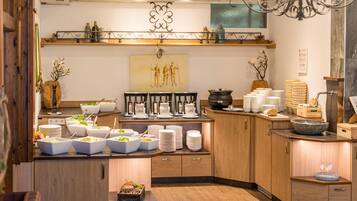 A well-lit kitchen area with wooden cabinets, a variety of food dishes, and a decorative wall piece.