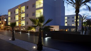 A modern hotel with multiple floors, balconies, and a pool area. - Ibiza Sun Apartments (Sant Josep de sa Talaia)