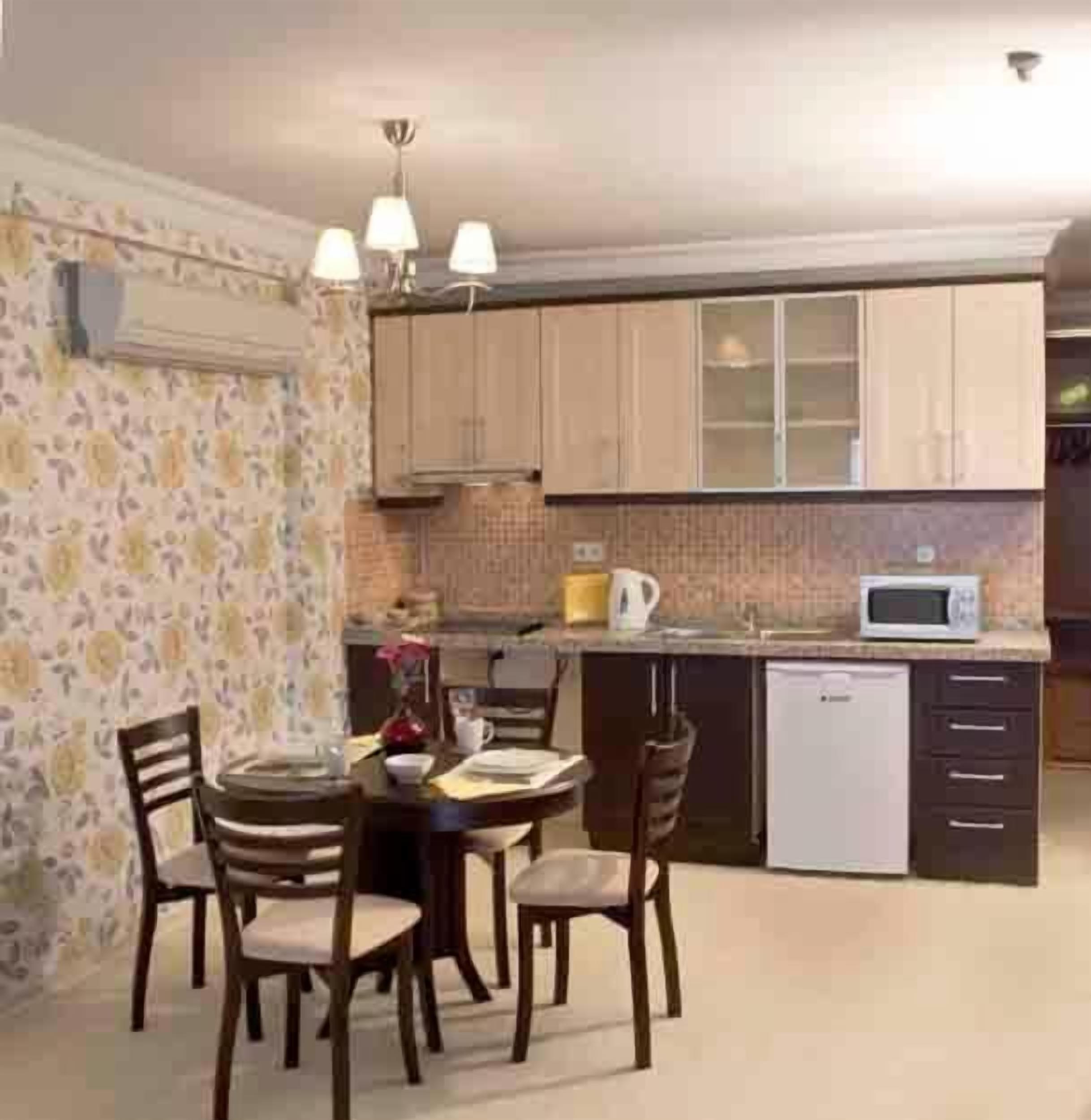 A compact kitchen with wooden cabinets, a microwave, and a dishwasher.