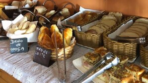 A buffet with various breads, pastries, and a sign indicating 'Dodo de Leite'. - Pousada Serra do Jordão (Campos do Jordão)