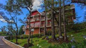 A multi-story hotel with balconies, surrounded by lush greenery and trees. - Pousada Serra do Jordão (Campos do Jordão)
