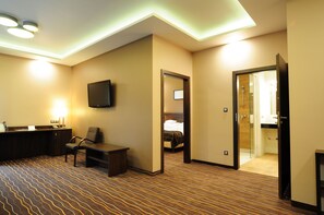 A hotel room with a reception desk, a television, a bed, and a shower area. - Hotel Zimnik Luksus Natury (Lipowa)