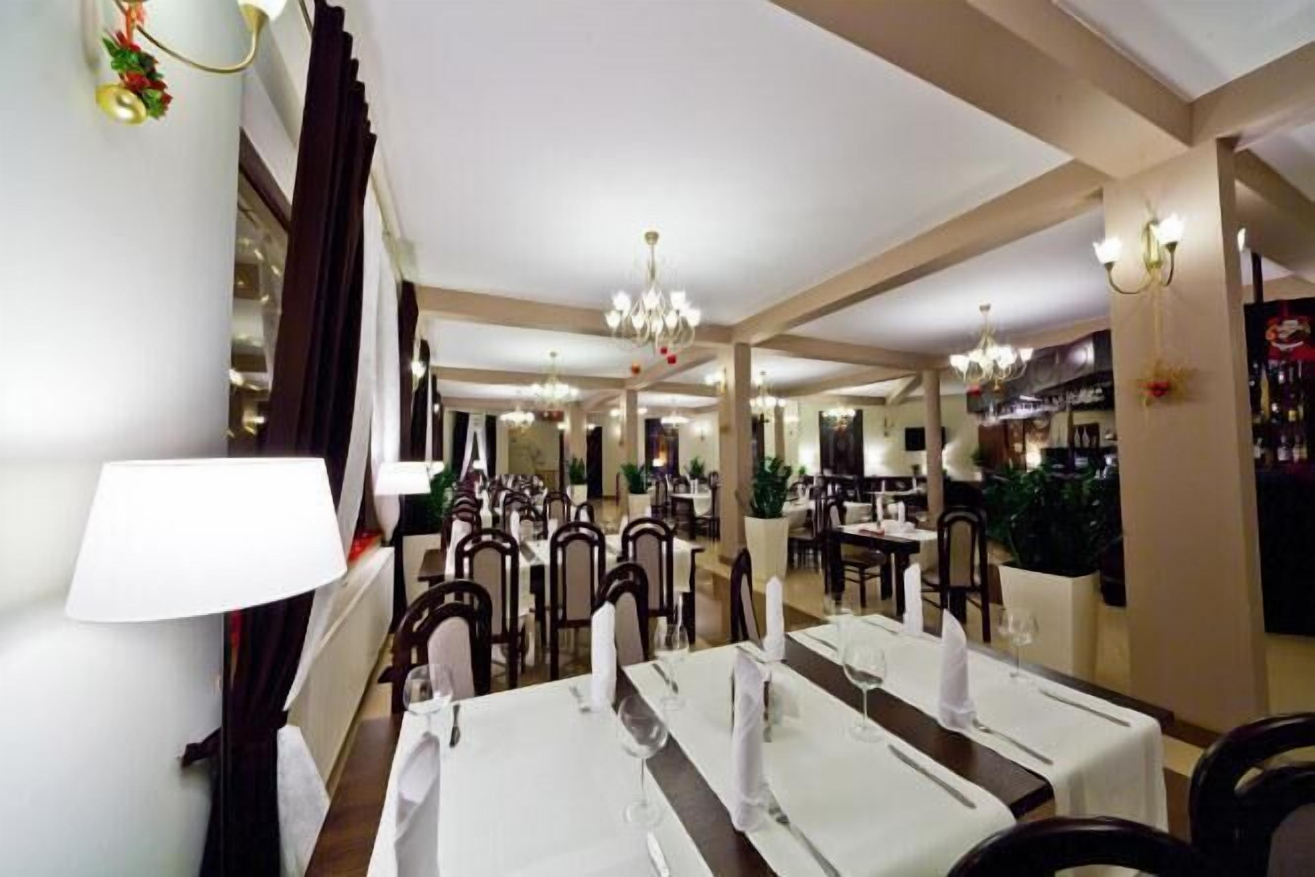 Àmplia zona de dinar amb diverses taules preparades per a convidats, amb lluminàries i un ambient càlid.
