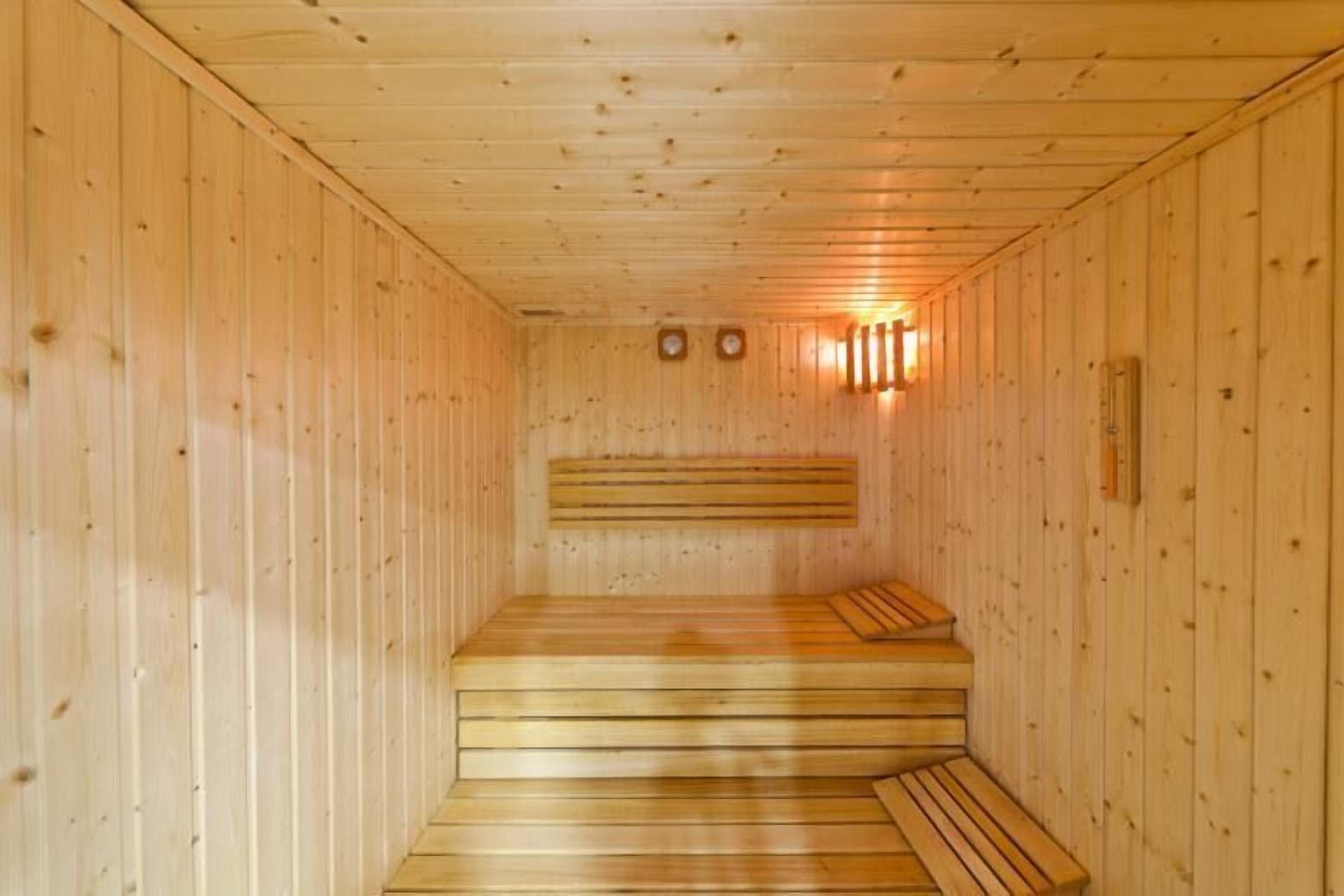 Un sauna con bancos de madera y una banca al final.