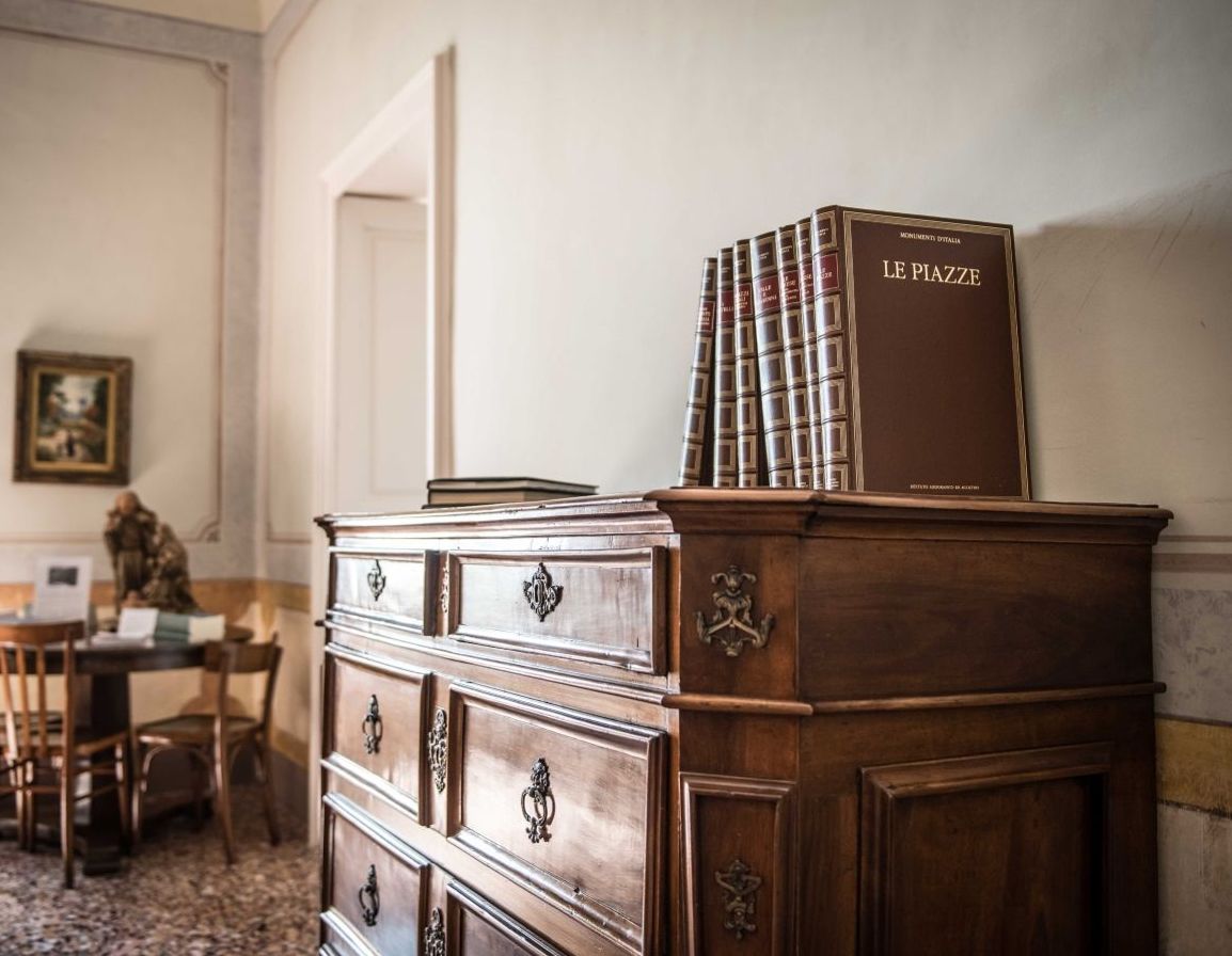Une commode en bois sur laquelle est posé un livre intitulé « LE PIAZZA ».