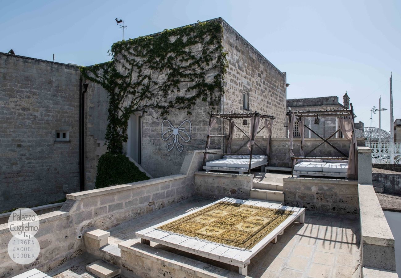 Une terrasse sur le toit, dotée d’un sol en pierre, d’une structure métallique décorative et offrant une vue sur le paysage urbain.